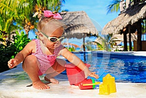 Little girl playing in swimming pool at tropical