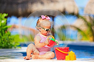 Little girl playing in swimming pool at tropical