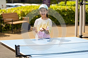 little girl playing table tennis in the tennis hall, tennis racket hitting the ball, the pitch of the ball.