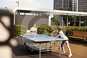 little girl playing table tennis in the tennis hall, tennis racket hitting the ball, the pitch of the ball.