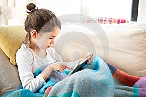 Little girl playing with a tablet