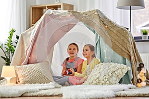 Little girl playing tea party in kids tent at home