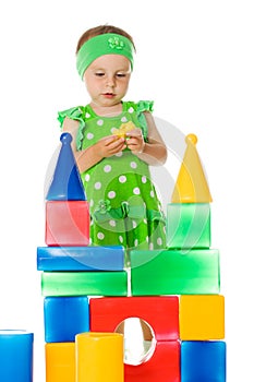 Little girl is playing with toy cubes