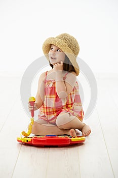 Little girl playing with toy instrument