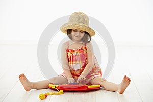 Little girl playing with toy instrument