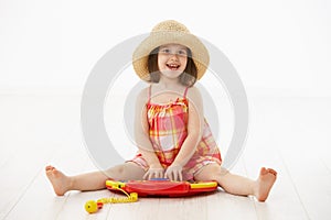 Little girl playing with toy instrument