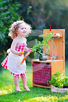 Little girl playing with toy kitchen