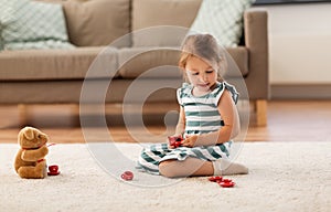 Little girl playing with toy tea set at home