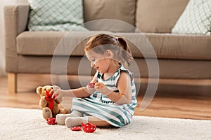 Little girl playing with toy tea set at home