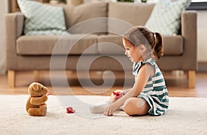 Little girl playing with toy tea set at home