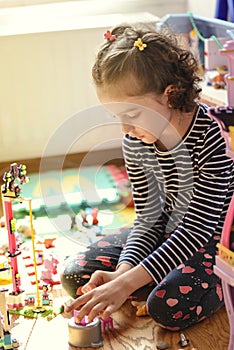 Little girl playing with toys in her room.