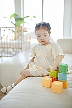 Little girl playing with toys at home