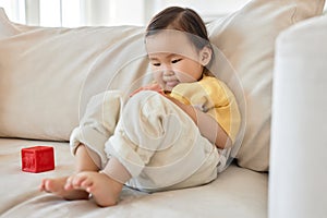 Little girl playing toys on sofa