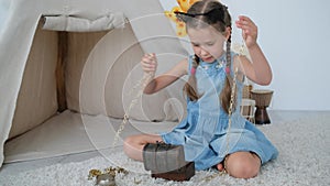 Little girl playing with treasure box