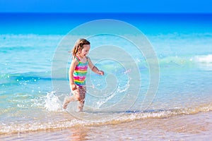 Little girl playing on tropical beach