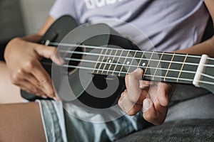 Little girl playing ukulele. Concept art and music. Focus on hand