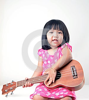 Little girl playing ukulele