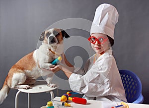 Little Girl playing veterinarian with dog