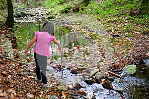 Little girl playing with water in a river