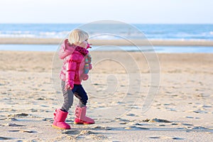 Little girl playing on winter beach