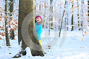 Little girl playing in winter forest