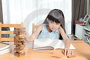 Little girl playing wood blocks stack game