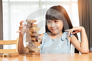 Little girl playing wood blocks stack game