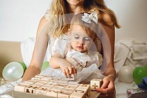 Little girl playing with wooden ABC blocks. Plastic-free wooden zero waste kids toys for safe and sustainable gifting. Eco