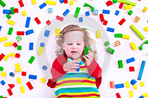 Little girl playing with wooden blocks