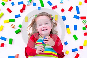 Little girl playing with wooden blocks