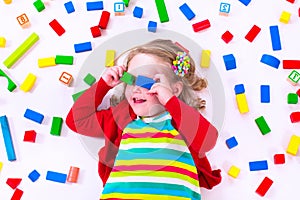 Little girl playing with wooden blocks