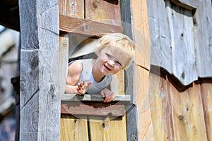 Little girl playing in wooden house in the park