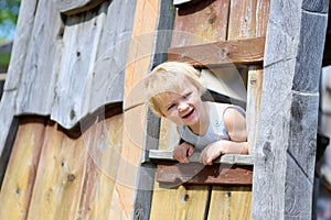 Little girl playing in wooden house in the park