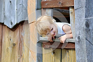 Little girl playing in wooden house in the park