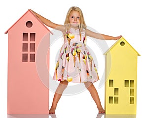 Little girl is playing with wooden houses.