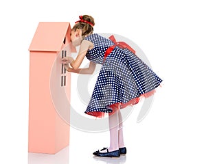 Little girl is playing with wooden houses.