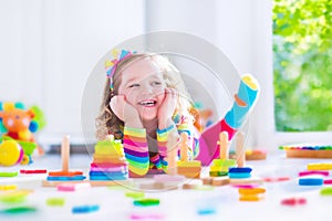 Little girl playing with wooden toys