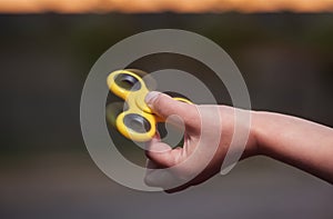 Little girl is playing a yellow spinner