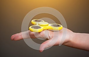 Little girl is playing a yellow spinner in her hand