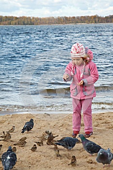 Little girl plays beach in autumn day