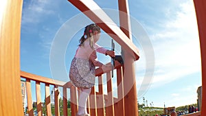 a little girl plays in a children's park on a toy ship, a child plays the captain of the ship and turns the steering