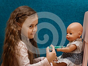 Little girl plays doctor, makes an injection to the doll