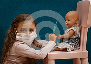 Little girl plays doctor, makes an injection to the doll