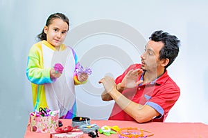 Little girl plays with her father at home in a beauty salon, combing her hair