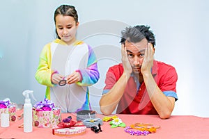 Little girl plays with her father at home in a beauty salon, combing her hair