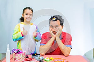 Little girl plays with her father at home in a beauty salon, combing her hair