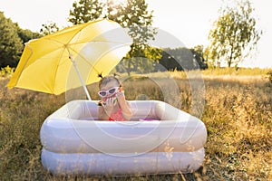 Little girl plays in the inflatable pool