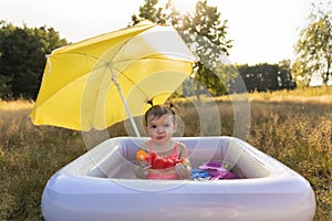 Little girl plays in the inflatable pool