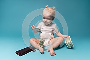 Little girl plays with money from mom`s wallet