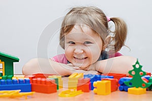 The little girl plays plastic blocks